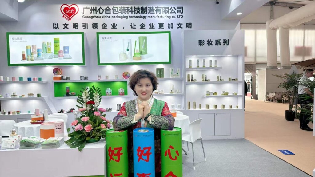 Xinhe founder at packaging exhibition booth with custom paper tube packaging samples