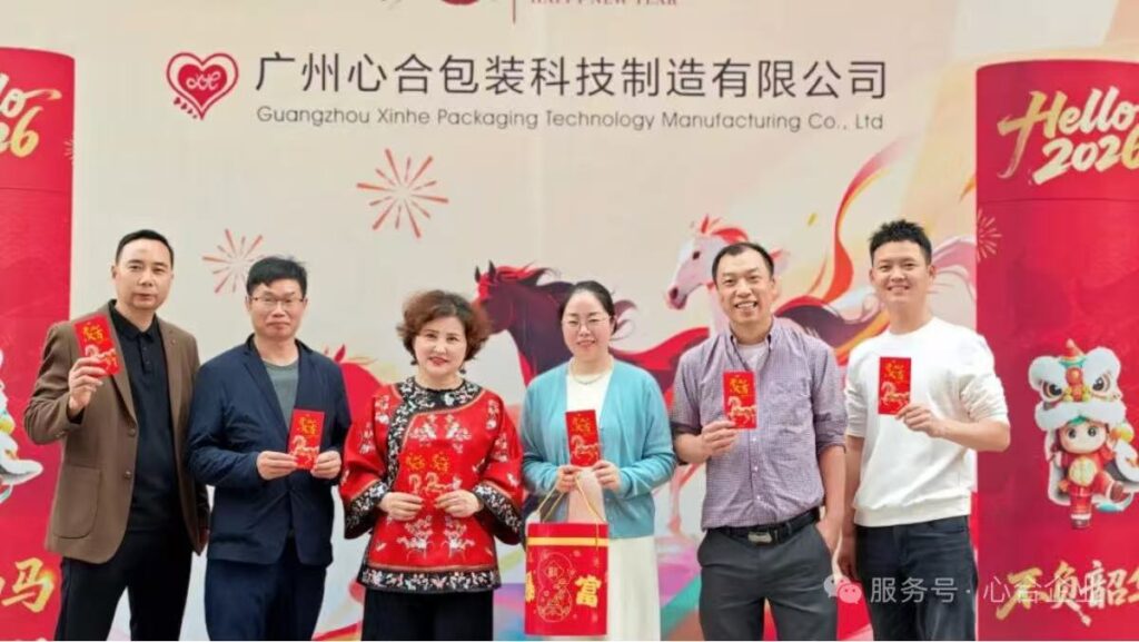 Xinhe packaging project team standing in front of the company backdrop for a 2026 team photo