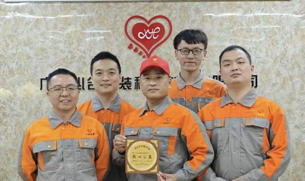 Xinhe quality control team in orange uniforms holding a public service award plaque