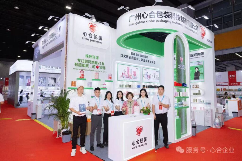 Xinhe export sales team at a packaging exhibition booth with custom paper tube samples
